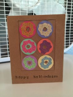 a card that has donuts on it and the words happy half - dozen written in black