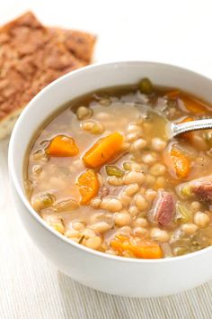 a white bowl filled with soup next to a piece of bread