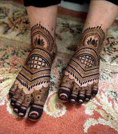 the feet and hands of a woman with henna tattoos