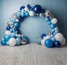 a blue and white balloon arch on the floor