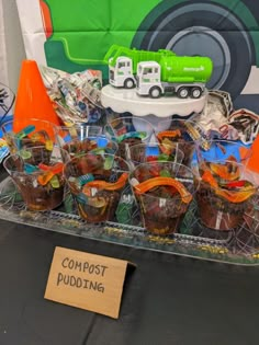 there are many cups on the table with construction hats around them and a sign that says compost puddinging