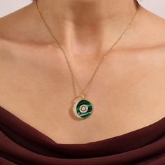 Discover lunar elegance with our Green Enamel Moon and Orbit Necklace, a celestial symphony of elegance and style. This enchanting piece features a fine gold chain adorned with a mesmerizing moon and orbit pendant on vivid green enamel. Inspired by the cosmos, this necklace captures the magic of the night sky, making it a celestial and elegant addition to your jewelry collection. - Made in 14k solid gold - Decorated with handset white cubic zirconia stone - Finished with Green Enamel - Pendant d Elegant Moon Charm Pendant Jewelry, Elegant Oval Jewelry With Moon Phase, Elegant Oval Moon Phase Jewelry, Celestial Pendant Necklace For Formal Occasions, Celestial Pendant Necklace For Formal Events, Elegant Round Moon Charm Necklace, Elegant Round Pendant Jewelry With Moon Phase, Elegant Round Necklace With Moon Charm, Elegant Moon Phase Pendant Jewelry