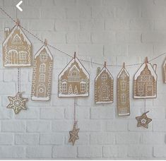 christmas decorations hanging on a string against a white brick wall with text overlay that reads, how to decorate gingerbread houses