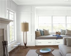 a living room filled with furniture and a fire place next to a white fireplace mantel