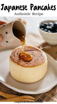 a person pouring syrup on top of a dessert