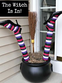 the witch is in halloween decoration with brooms and witches'legs on top of a black pot