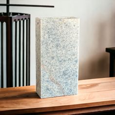 a white marble block sitting on top of a wooden table next to a black metal radiator