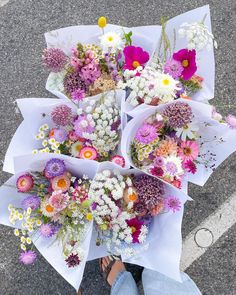 a bunch of flowers that are laying on the ground next to someone's feet