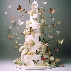 a wedding cake with butterflies flying around it