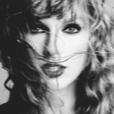 a black and white photo of a woman's face with hair blowing in the wind