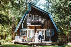 a man and woman standing on the porch of a cabin