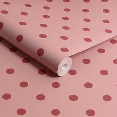 a pink and red wallpaper with polka dots