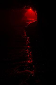 a red light shines on the water at night