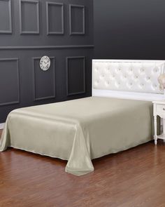 a white bed sitting on top of a hard wood floor