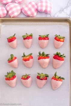 strawberries are arranged in the shape of hearts on a baking sheet