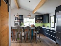 a kitchen with wooden floors and black cabinets