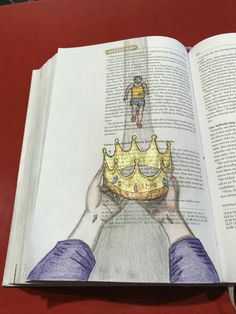 an open book with a drawing of a man holding a crown on top of it