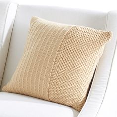 a white chair with a knitted pillow on it and the text classic textures pillow