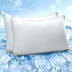 two white pillows sitting next to each other on top of snow flakes and ice