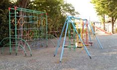 an empty playground with swings and climbing bars