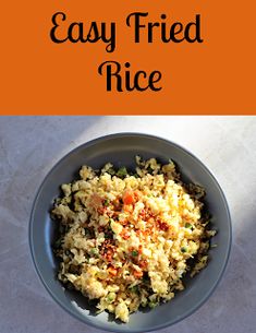 a bowl filled with rice and vegetables on top of a white tablecloth next to an orange sign that says easy fried rice