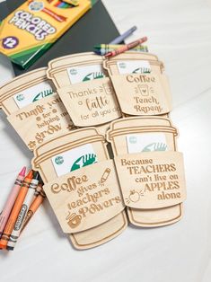 wooden teacher appreciation tags with crayons and pencils next to them on a table