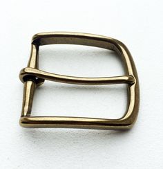 a gold metal belt buckle on a white background