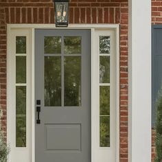 a gray front door on a brick house