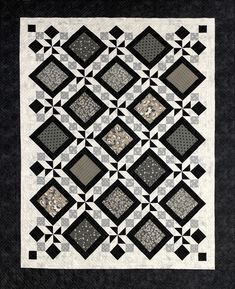 a black and white quilt with squares on the front, along with an intricate design