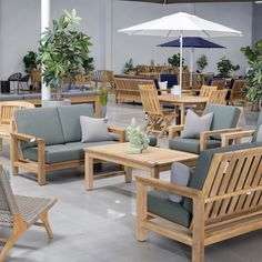 an outdoor seating area with chairs, tables and umbrellas in the middle of it