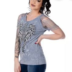 Liberty Wear Women’s Torn Apart Embellished Short Sleeve Tee Stunning Winged Cross Design Embellished With Rhinestones On Front, And Beautiful Graphic Design On Back Seductive Shoulder Slits Extremely Soft And Lightweight Classic Round Neckline Made In The U.S.A. Brand New With Tags 95% Cotton, 5% Spandex Approximate Measurements: Armpit To Armpit: 19” Length: 28.5” Size: Medium Please Note: The Stock Photo Shows A Model Wearing The Same Shirt But In A Different Color Shade. The One For Sale Is Casual Embellished T-shirt, Casual Embellished T-shirt For Spring, Blue Embellished Short Sleeve Top, Blue Embellished Top With Short Sleeves, Casual Embellished Tops For Spring, Spring Embellished Short Sleeve Tops, Spring Casual Embellished Tops, Embellished Short Sleeve Tops For Spring, Embellished Shorts