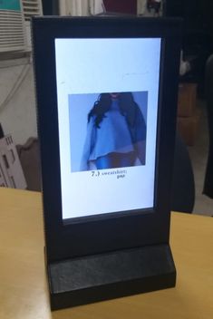 an image of a woman's dress is displayed in a frame on a table