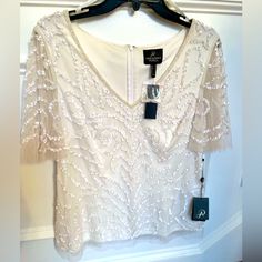 Add Some Much Needed Sparkle To Your Holiday Celebrations With This Elegant Adrianna Papell Beaded Ivory Top. It Is Lined, A Size 12, It Fits Beautifully. While It Coordinates Well With The Pictures Black And Ivory Skirt, It Is Being Sold Separately. Elegant Cream Embellished Tops, Spring Formal Beaded Tops, Elegant Beaded Tops For Wedding, Elegant Beaded Tops For Spring, Elegant Beaded Short Sleeve Tops, Elegant Beaded V-neck Tops, White Off Shoulder Top, Ivory Skirt, Wrap Top Blouse