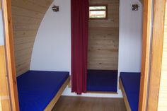 the inside of a small cabin with blue mattresses