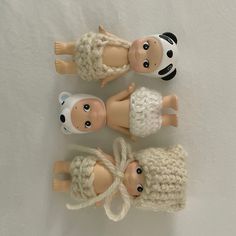 three little dolls are wearing knitted clothes