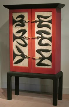 a red cabinet with black and white designs on it