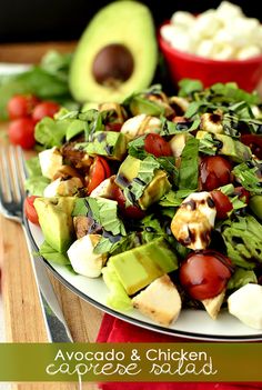 a salad with avocado, tomatoes and other vegetables