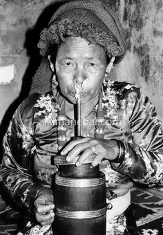 an old black and white photo of a woman blowing on a candle