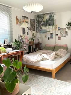 a bed sitting in a bedroom next to a window with lots of pictures on the wall