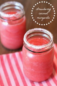 two mason jars filled with pink liquid on top of a red and white table cloth