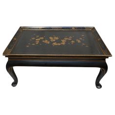 a black and gold coffee table with flowers on it