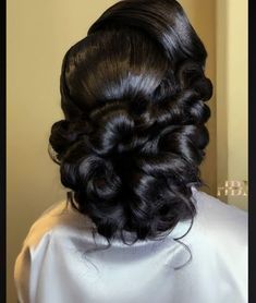 the back of a woman's head, with her hair curled up in a low bun