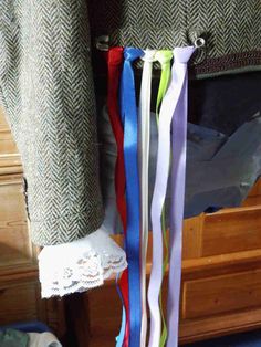 several ribbons are hanging from the side of a bed in front of a wooden dresser