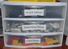 three drawers with legos and white gray pieces labeled in black letters on them, sitting next to each other