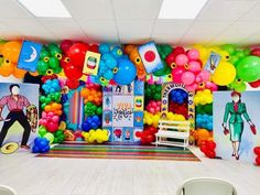 the room is decorated with balloons and pictures on the wall, along with white chairs