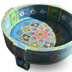 an artisticly painted wooden bowl with flowers on the inside and sides, is shown