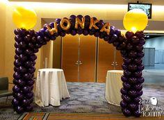 an arch made out of balloons with the word honka on it in front of a table