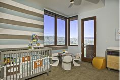 a baby's room with striped walls and furniture