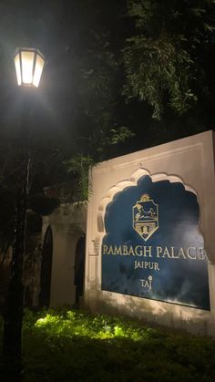 the sign for tambagh palace in jajpur at night with street lamp