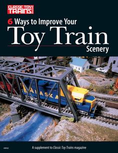 there is a book about toy trains on the cover, and it's title says 6 ways to improve your toy train scenery